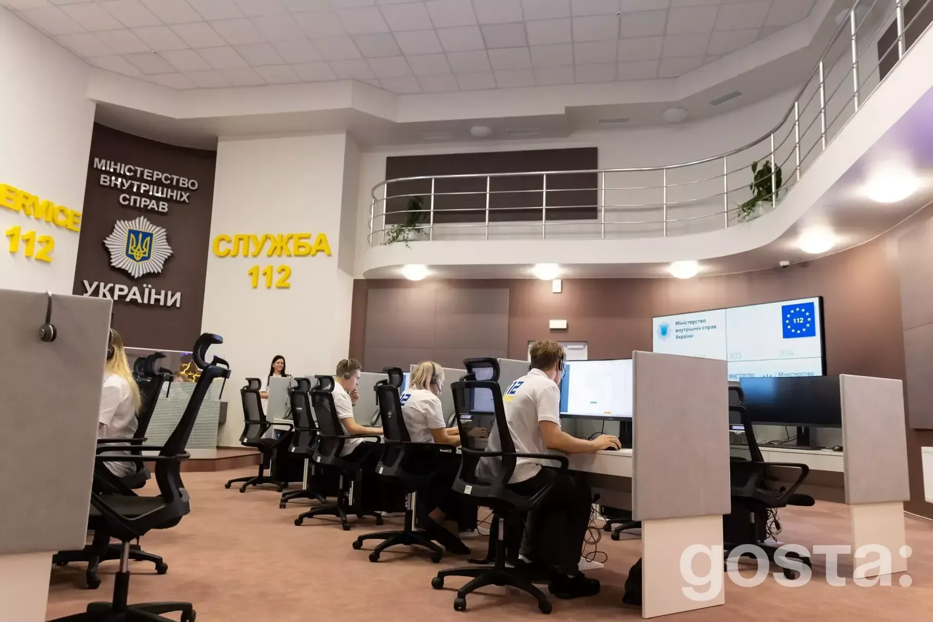 Співробітники Служби 112 України працюють у сучасному операційному центрі з великими моніторами та панелями.