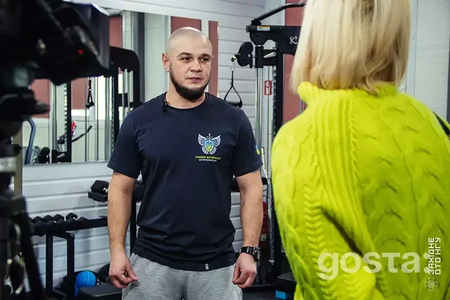 Чоловік у спортивній формі спілкується з жінкою в реабілітаційному центрі 50-го полку Нацгвардії України.