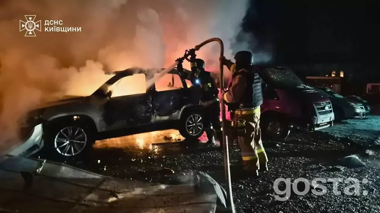 Emergency responders tackle a fire in vehicles after a Russian attack in Ukraine, highlighting the ongoing crisis in Kyi