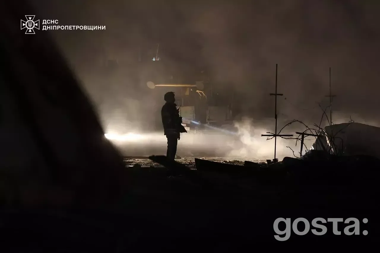 Рятувальник гасить пожежу в Дніпрі після ворожого обстрілу, постраждали мирні жителі, зокрема діти.