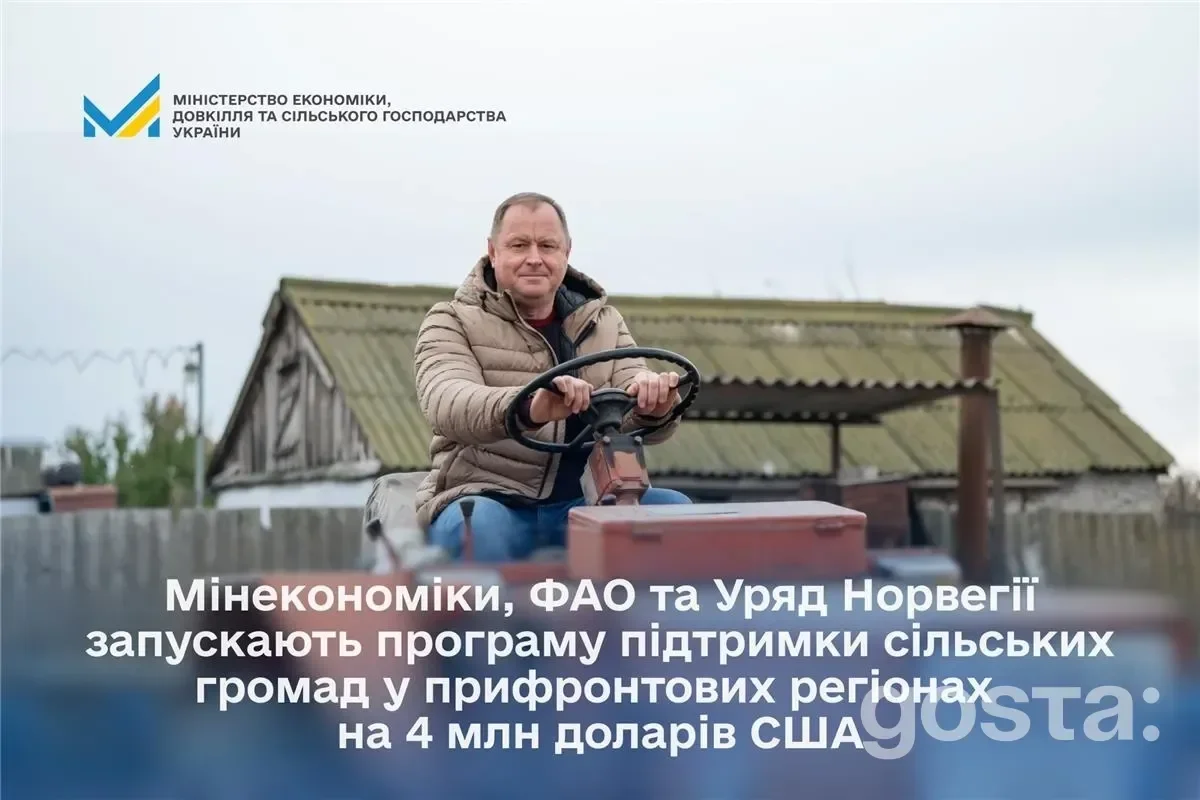 Чоловік на тракторі перед сільськогосподарськими будівлями; програма підтримки сільських громад України.