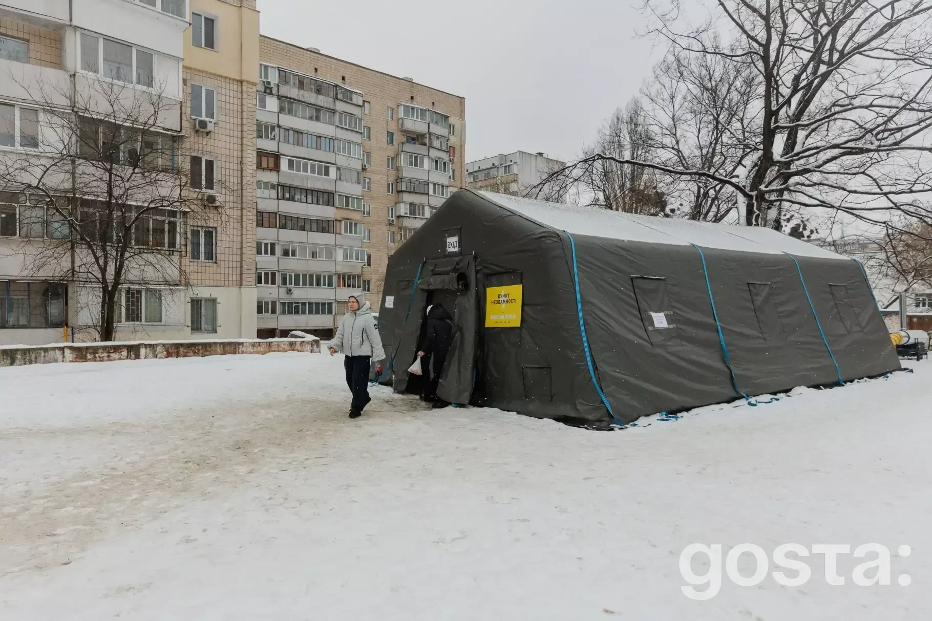 Намет Пункту Незламності ДСНС України в засніженому Києві, де люди можуть зігрітися та зарядити гаджети.