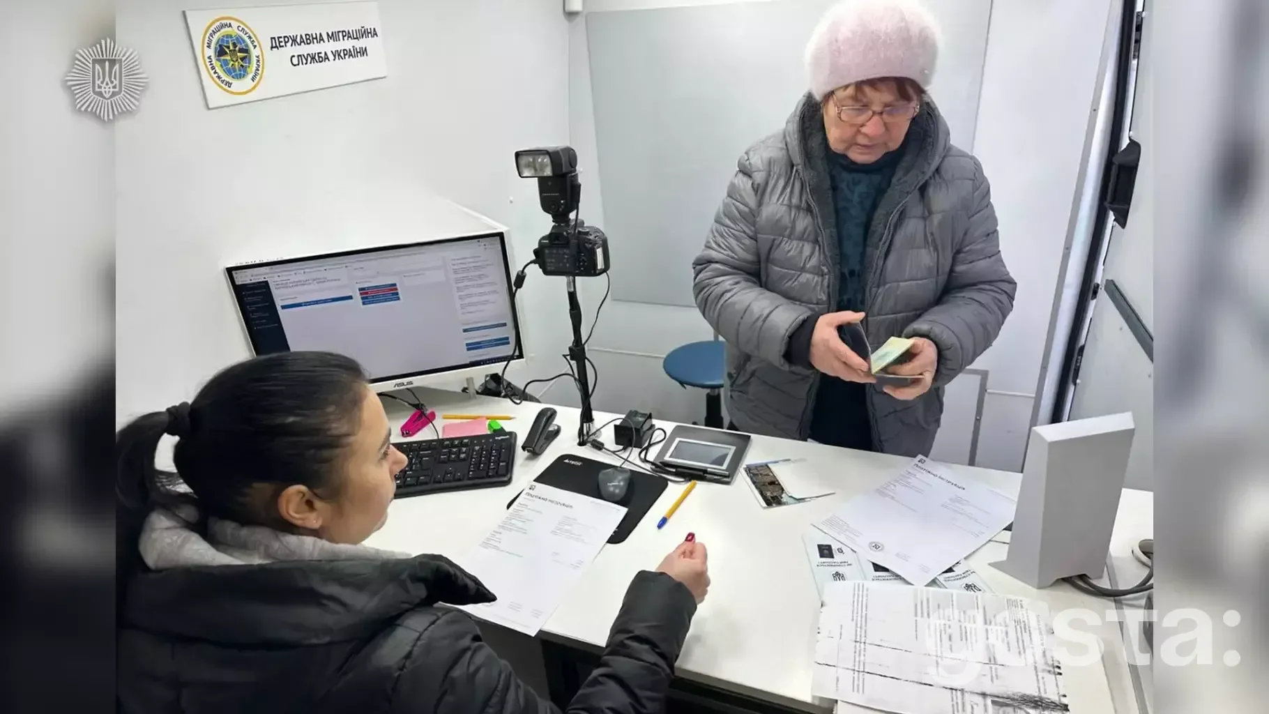 На фото мобільна група ДМС України приймає документи для біометричних паспортів у віддаленому пункті.