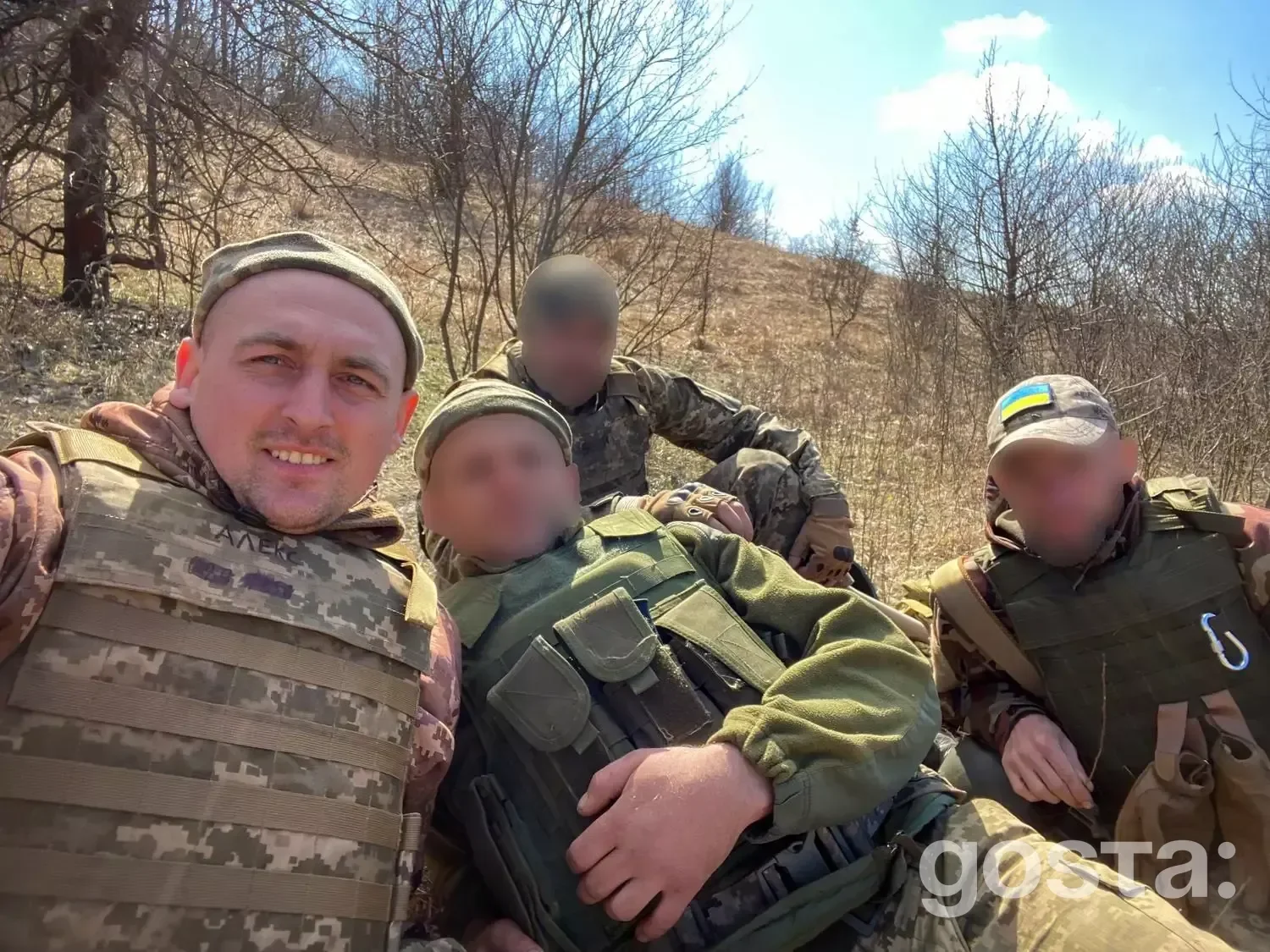 Ветерани у військовій формі відпочивають на природі; один військовослужбовець усміхається на камеру.
