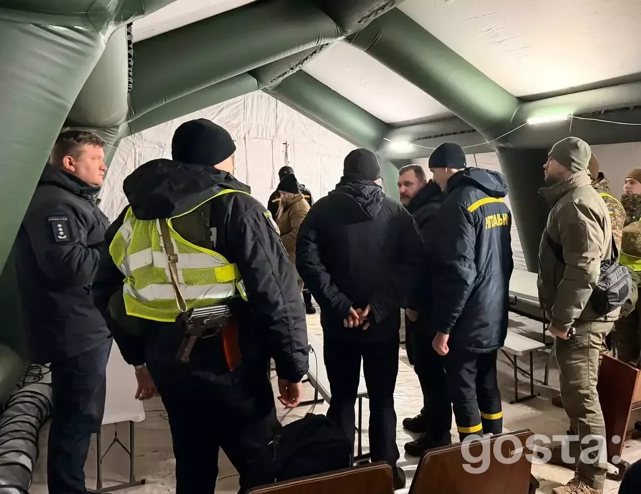 Люди в теплому наметі ДСНС у Києві обговорюють розгортання пунктів обігріву.