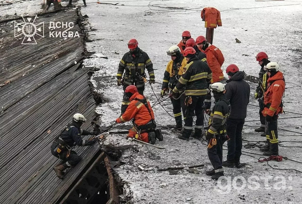 Рятувальники ДСНС працюють на зруйнованій будівлі взимку в Києві. Команда в захисному одязі проводить роботи.