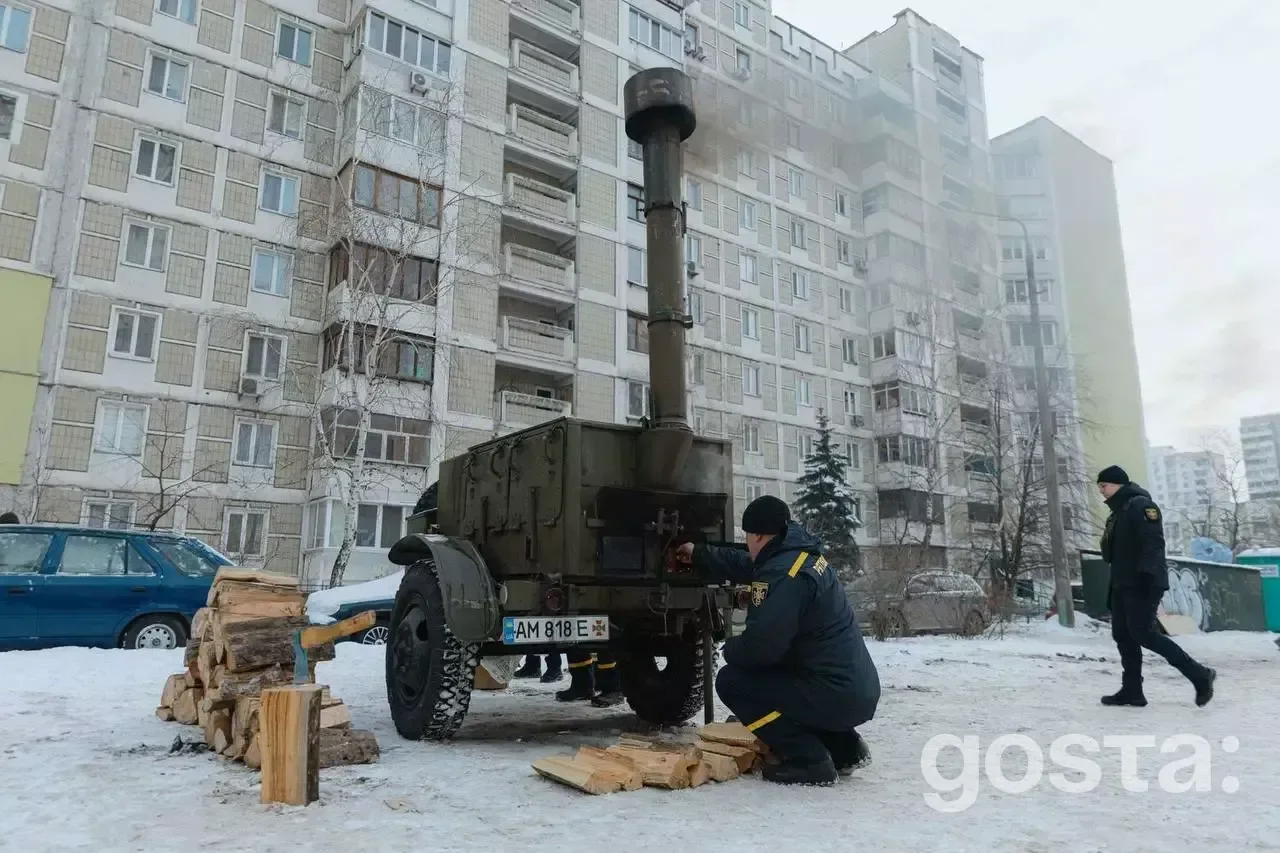 На фото: рятувальник біля мобільної печі в Києві, розгорнуті намети обігріву біля багатоповерхівок у зимових умовах.