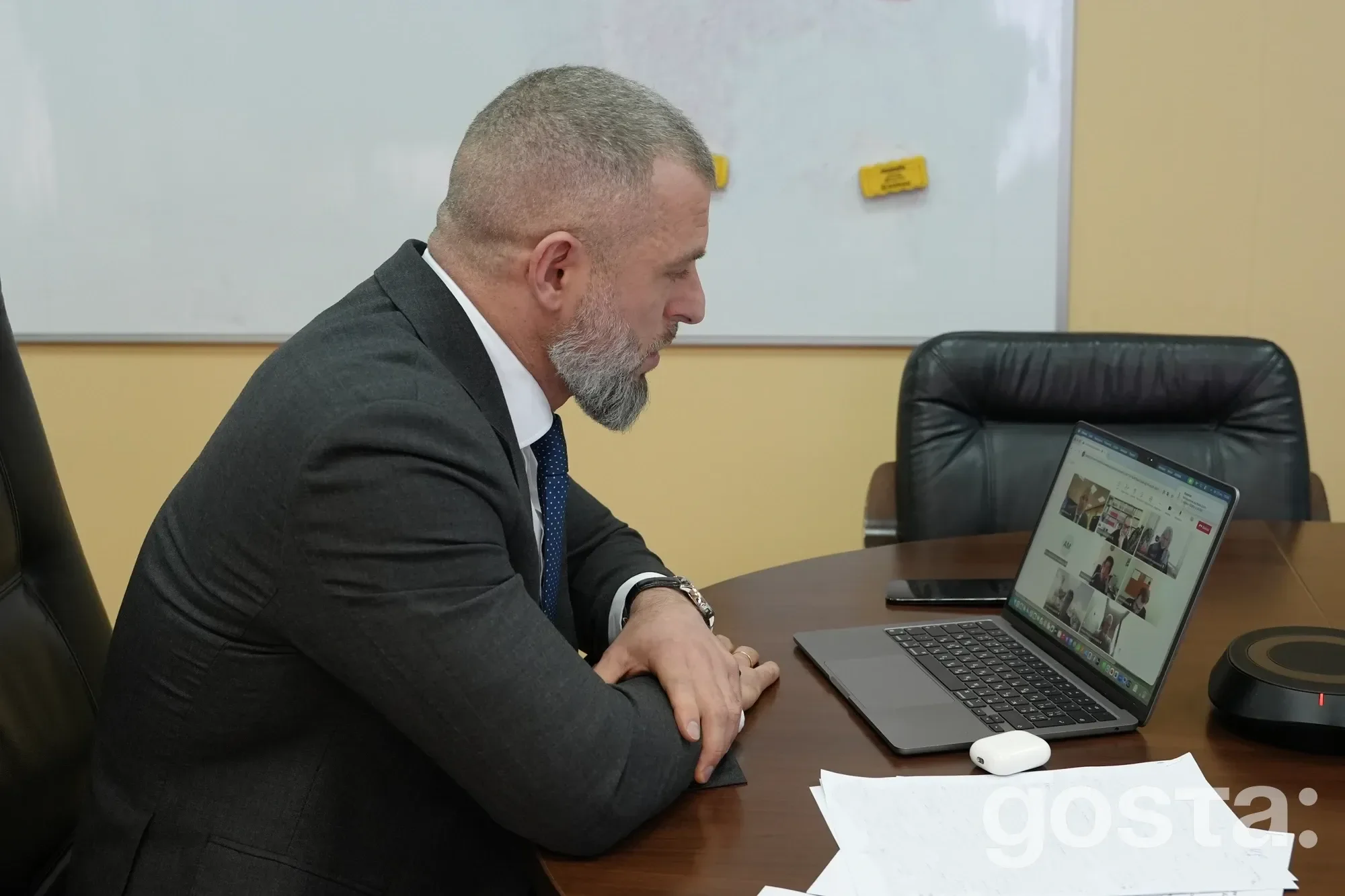 На зображенні урядовець за комп'ютером бере участь в онлайн-зустрічі між Україною та Швейцарією з питань молоді і спорту