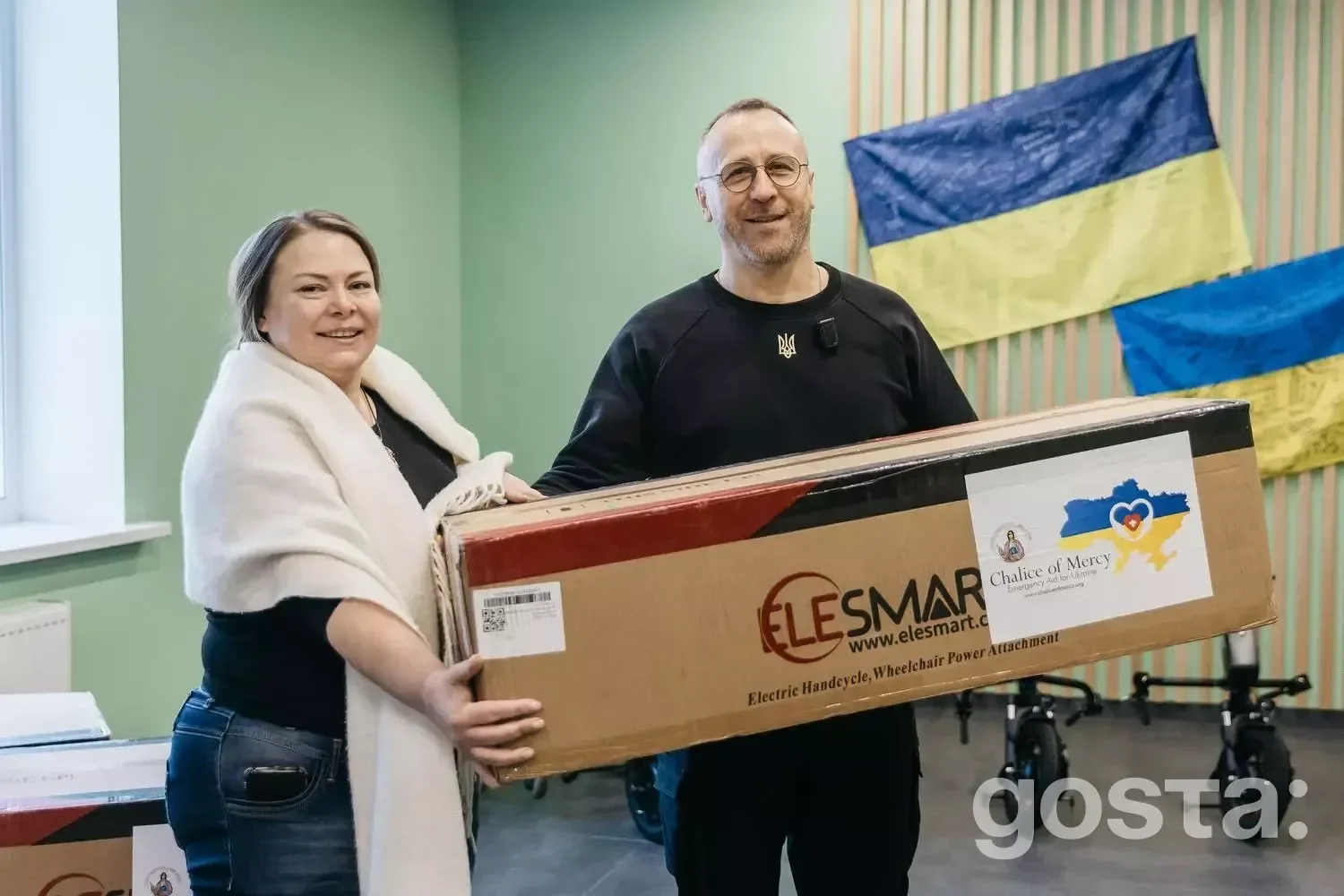Чоловік і жінка тримають коробку з електроприводом для реабілітації в госпіталі в Україні.
