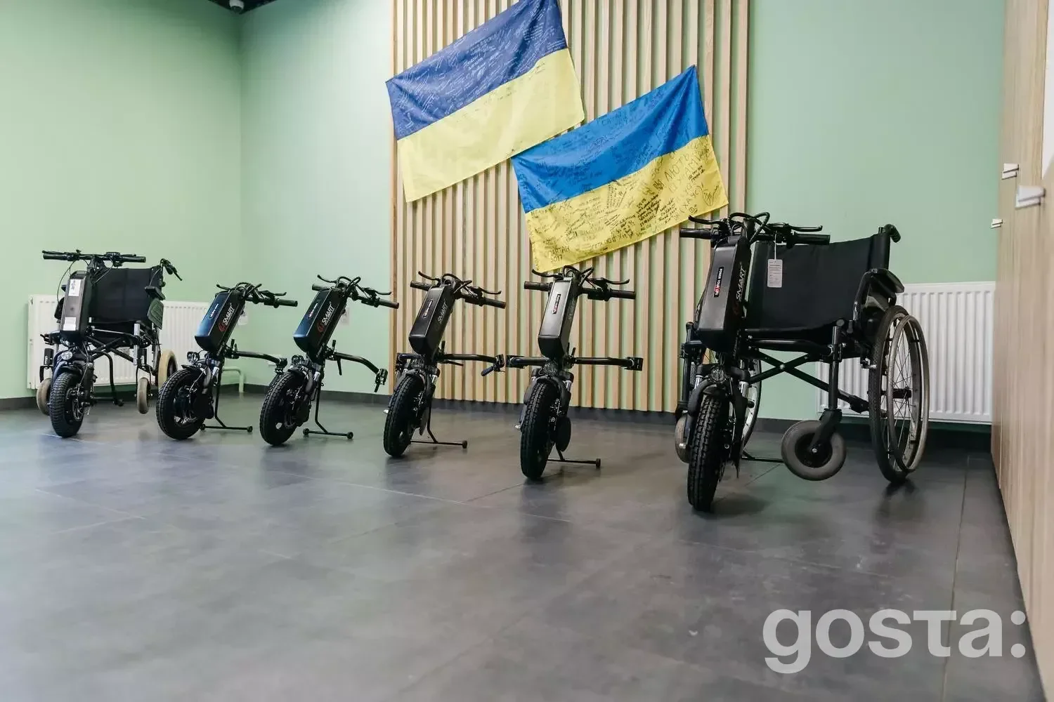 Реабілітація ветеранів: електроприводи для крісел колісних на тлі прапорів України у медичному центрі.