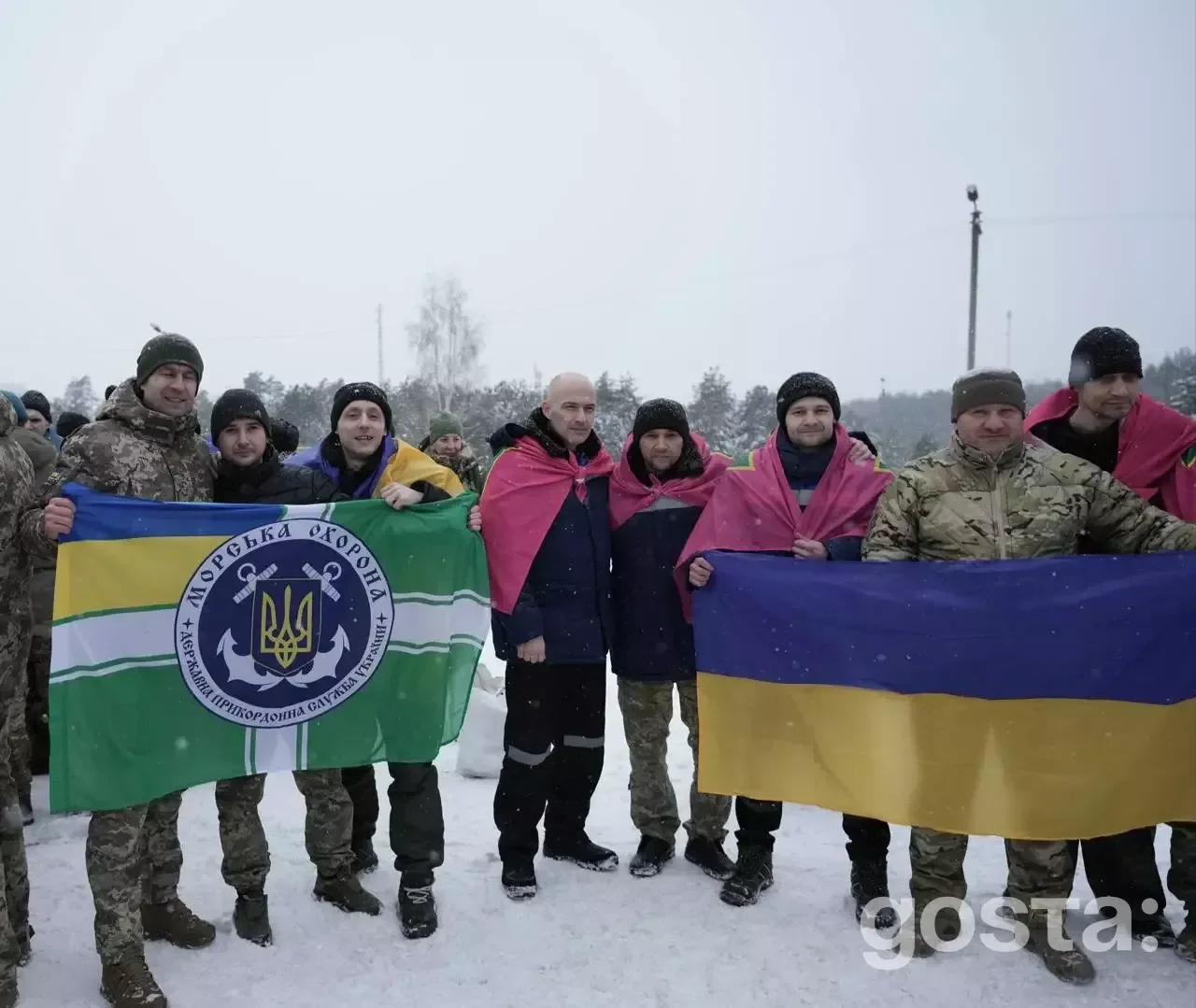 Я не можу сказати, хто на цьому фото.
Альтернативний текст: Група людей в зимовому одязі тримає українські прапори, ст