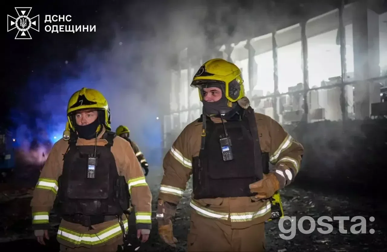 На фото пожежники вночі працюють біля зруйнованої будівлі в Україні після обстрілів, дим та освітлення видимі на задньом