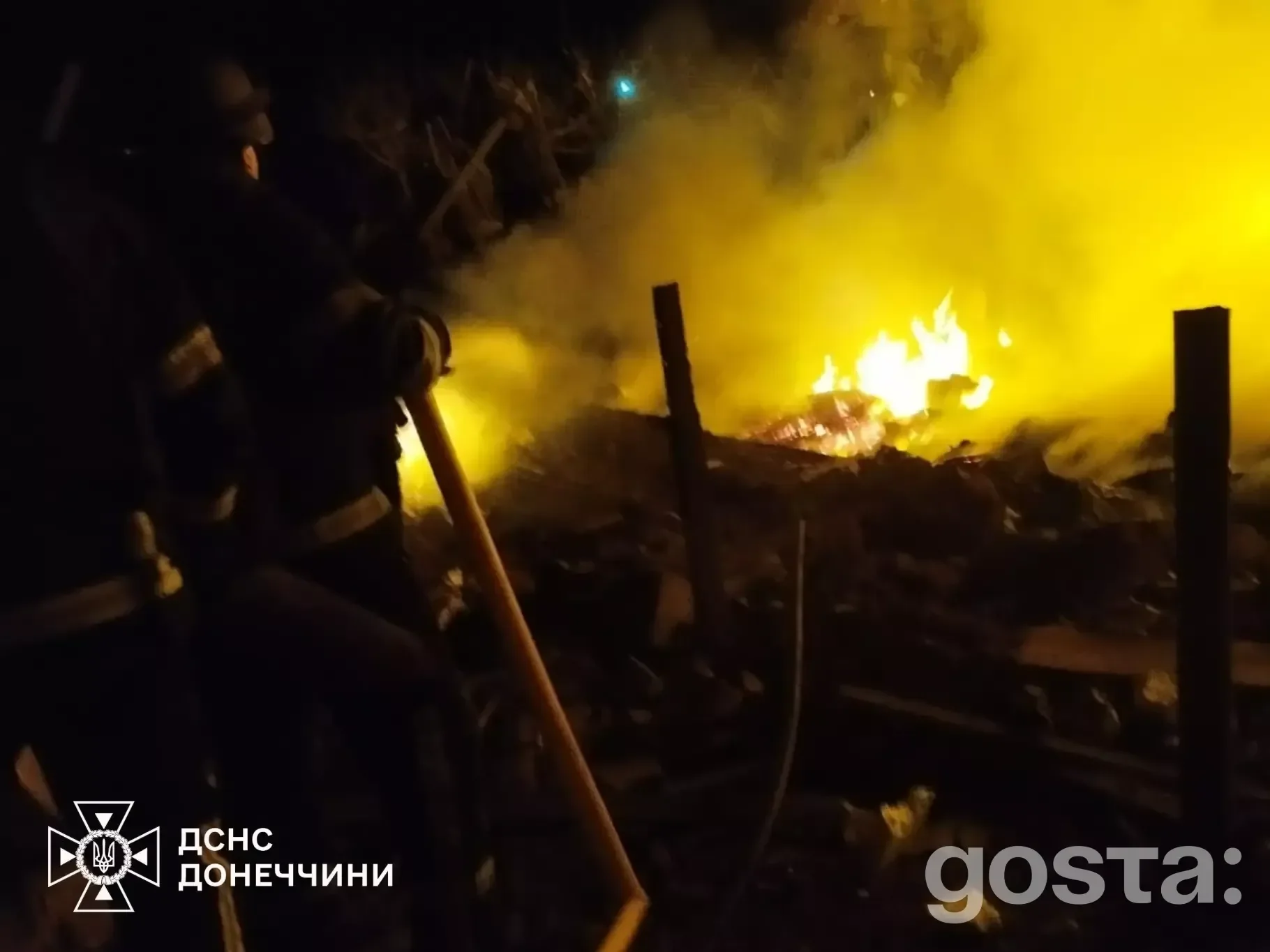 Рятувальники гасять пожежу після обстрілу в Донецькій області, робота вночі, вогонь на тлі руйнувань.